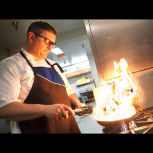 Chef Matthew cooking special dietary meal in RockRidge Canyon camp kitchen